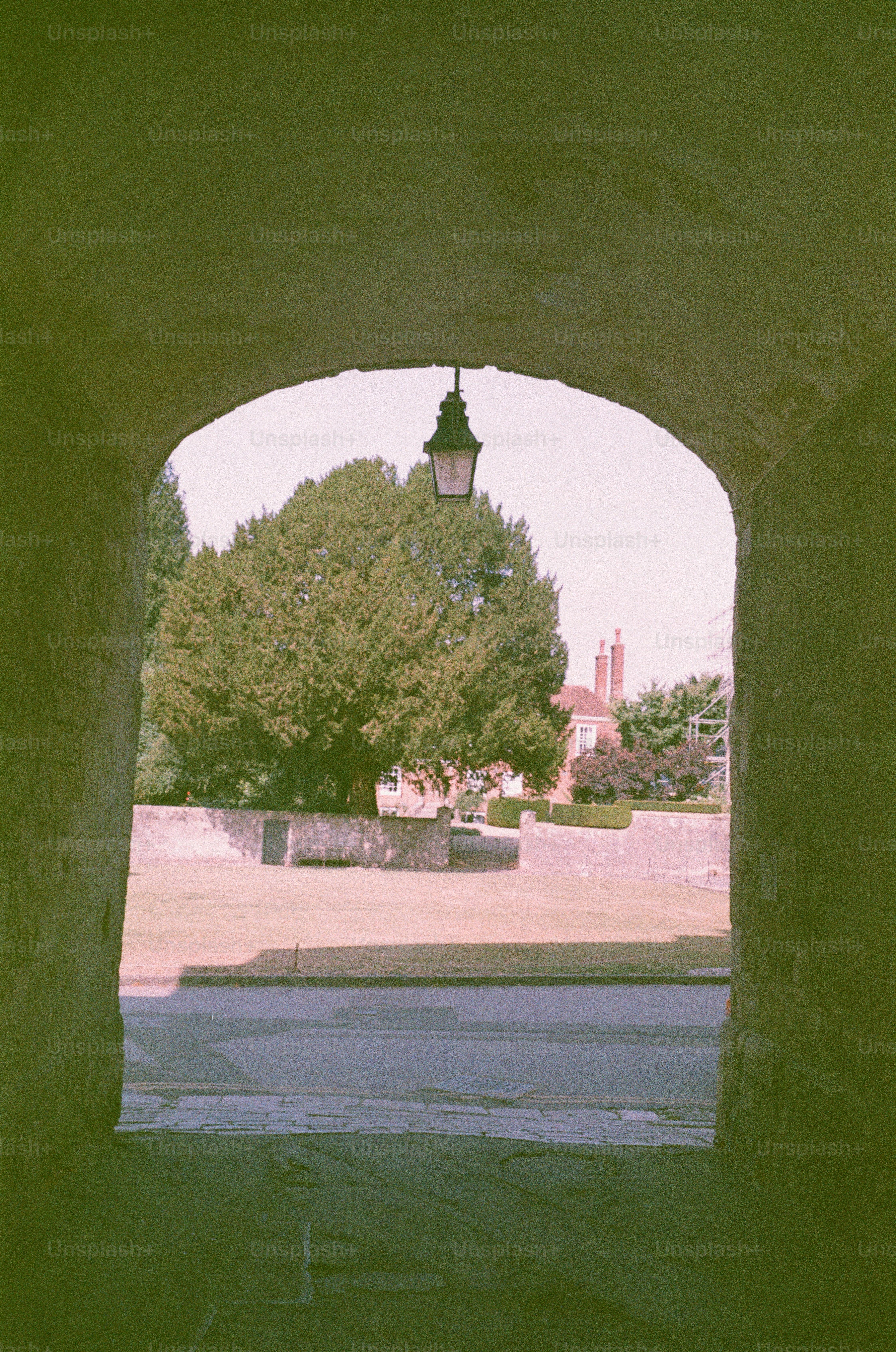 View through stone archway to garden and house